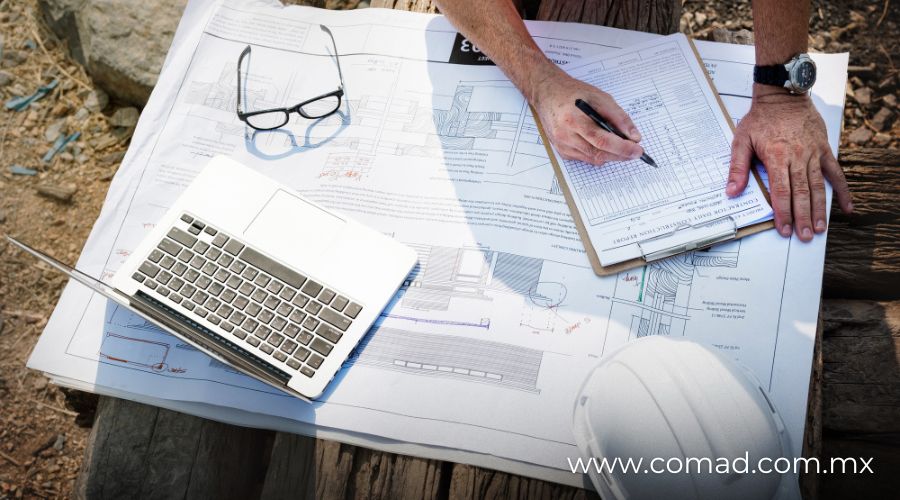 Perito en construcción revisa planos y documentos técnicos durante una reunión de obra pública para resolver controversias.